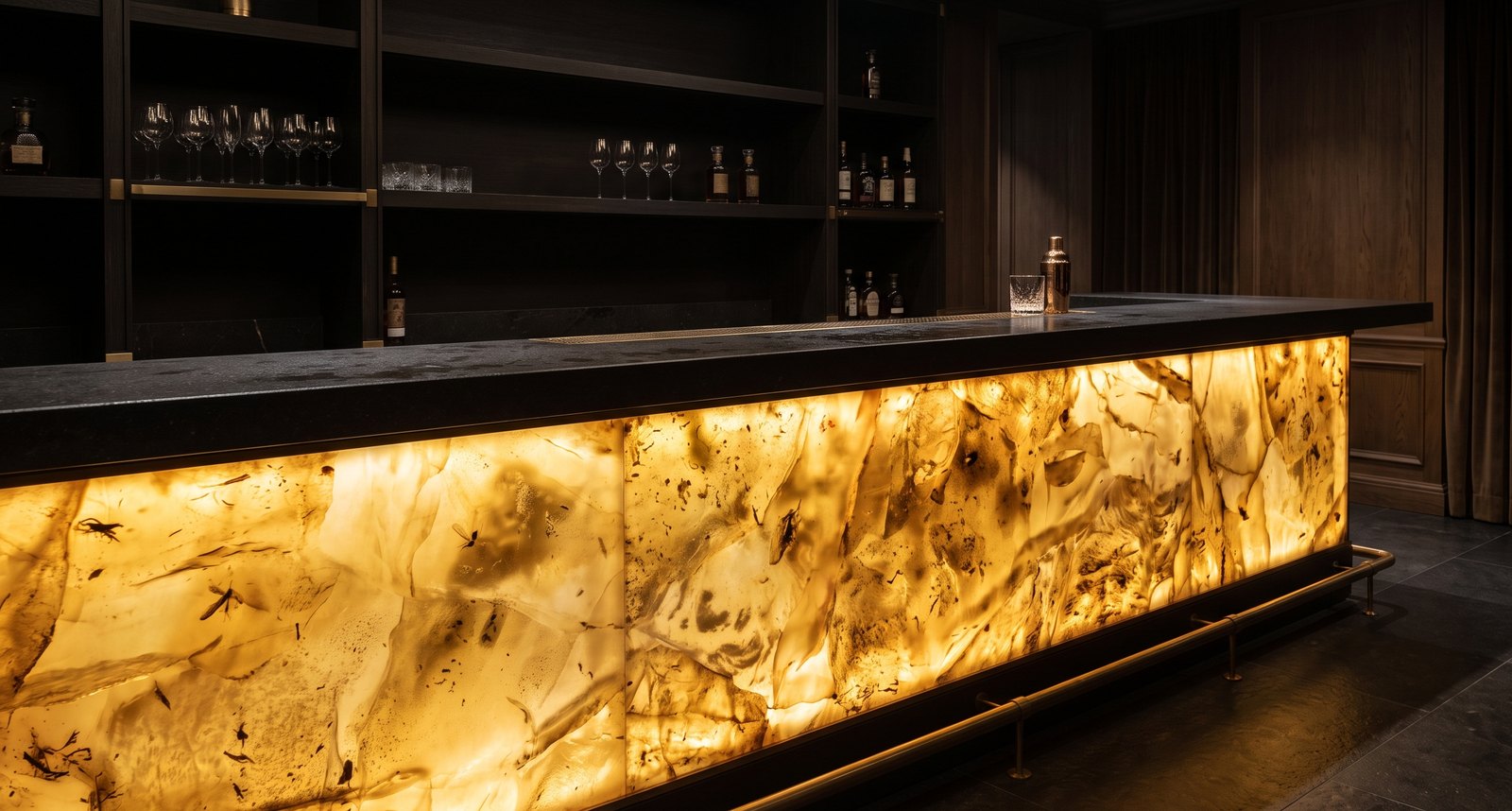 Hotel bar counter faced with one continuous backlit amber panel